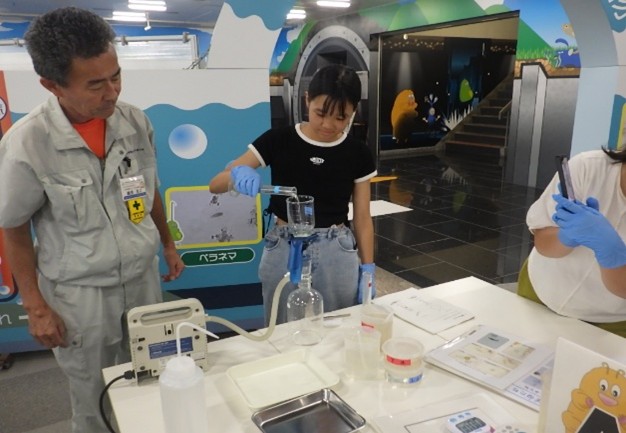 水質実験で顕微鏡をのぞく参加者