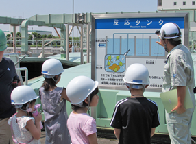 水循環センター内の施設を児童に説明する写真