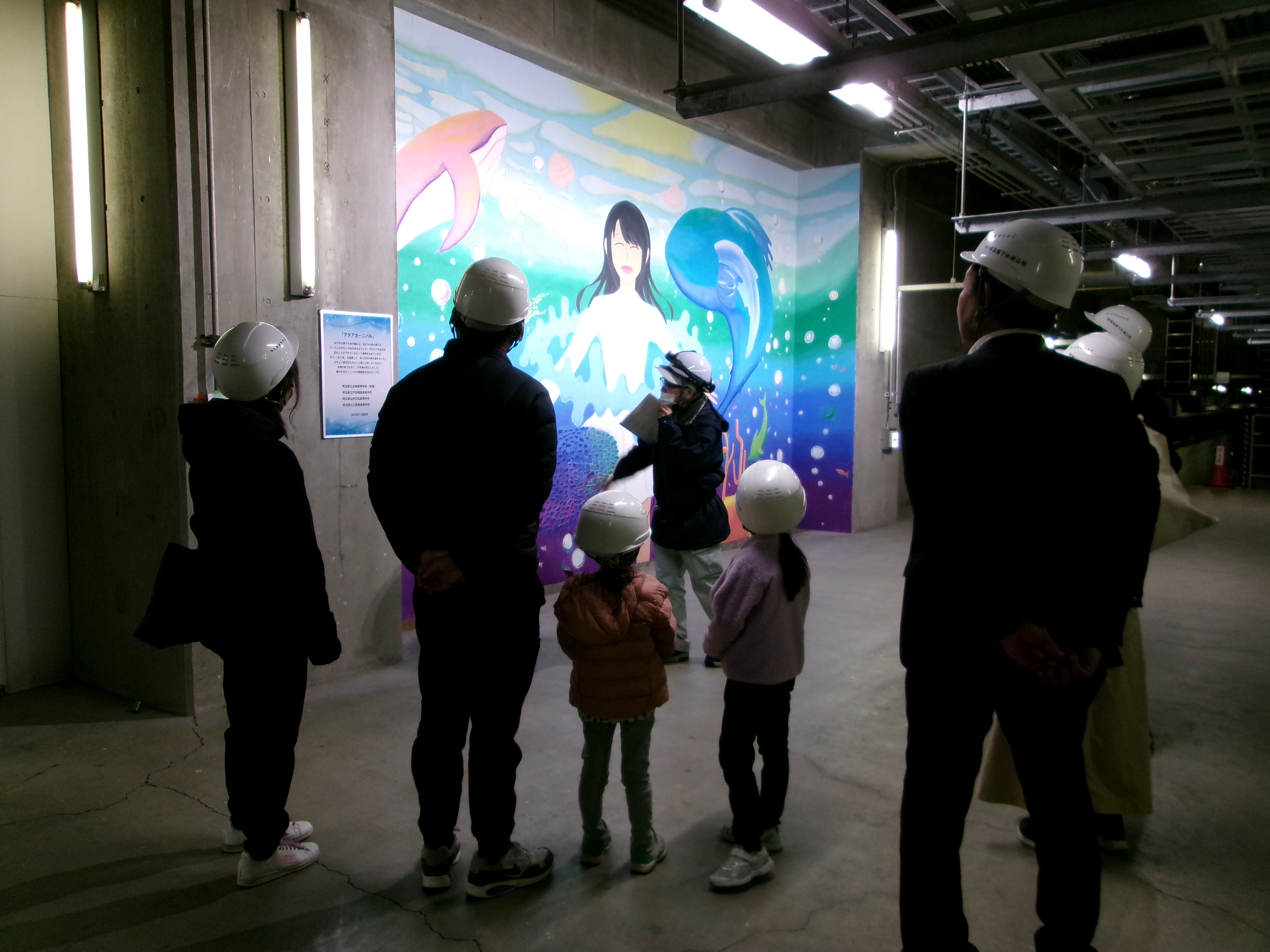 施設内の壁画を見学する参加者親子