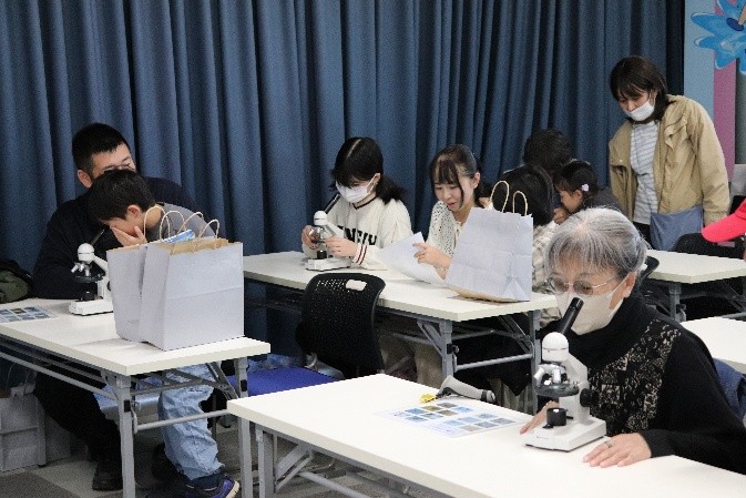顕微鏡で微生物を観察する参加者2名